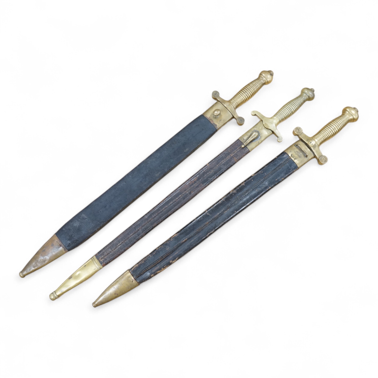 Three Continental infantry officer’s sidearms briquette, the first stamped Paris, in its brass mounted leather scabbard, another similar with sawback blade (illegible stamp), and another similar with thin blade, stamped